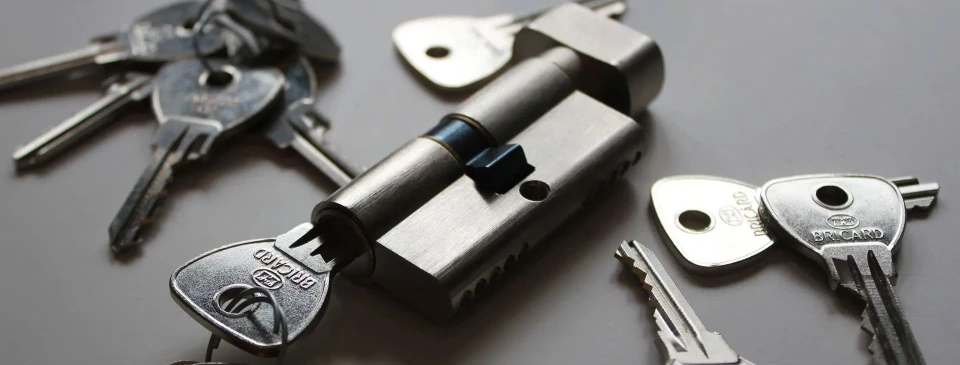 Un serrurier professionnel installe une serrure sur une porte d'entrée blanche dans un intérieur résidentiel