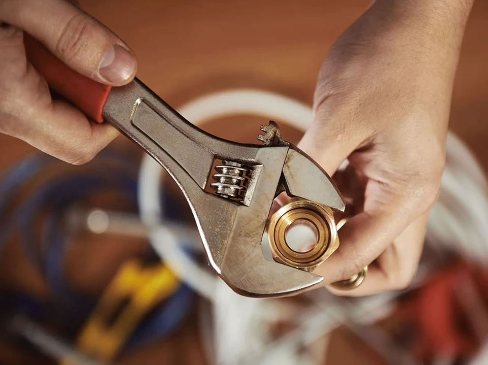 Atelier de plomberie avec outils professionnels disposés sur établi en bois