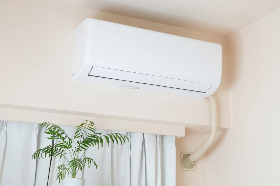 Un homme installe une serrure sur une porte intérieure blanche dans un couloir résidentiel