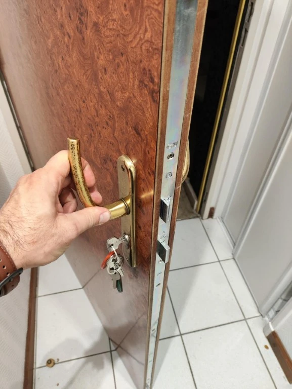 Scène d'intérieur montrant des mains manipulant un mécanisme de serrure