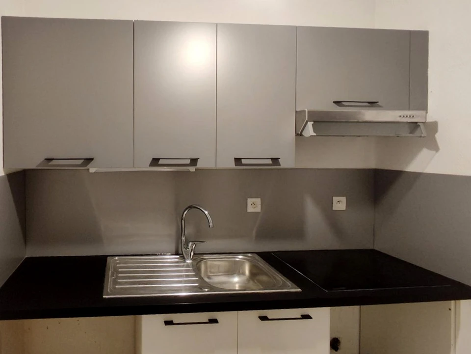 Chantier de travaux publics en extérieur avec ouvrier en gilet haute visibilité orange inspectant une canalisation dans une tranchée