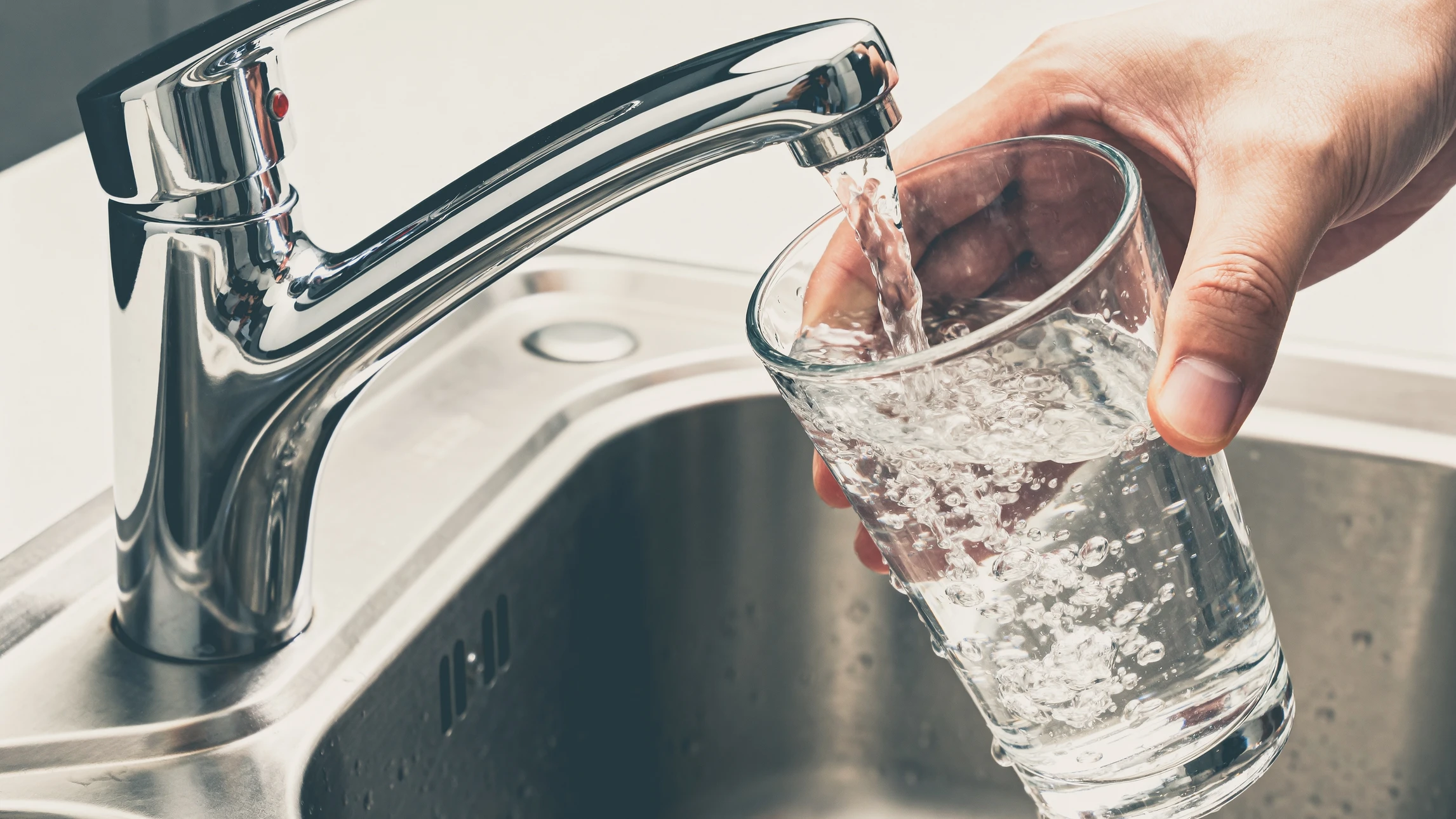 Distributeur de savon liquide mural installé sur un mur en pierre naturelle