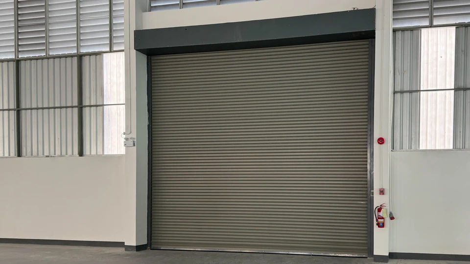 Mécanicien automobile travaillant sous le capot d'un véhicule, utilisant un tournevis pour effectuer une réparation ou maintenance moteur