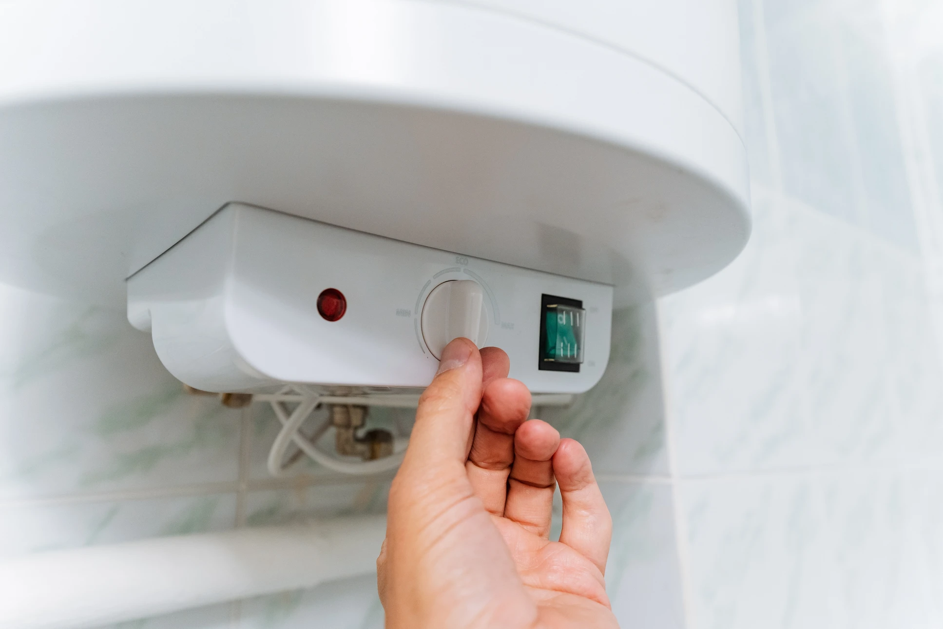 Installation d'eau domestique - le plombier resserre une capsule sur les canalisations d'eau chaude et froide